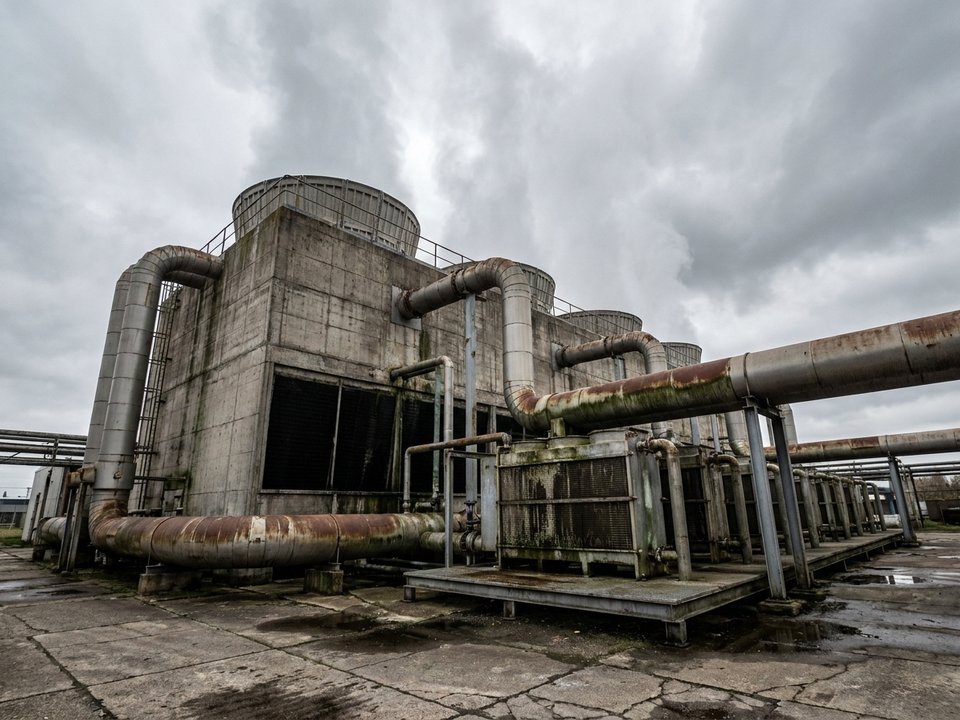 Industrial cooling tower with rising water vapour and connected heat exchanger pipework